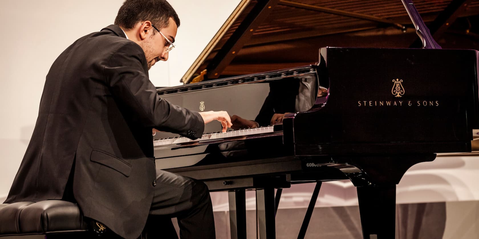 Man playing a Steinway & Sons grand piano.