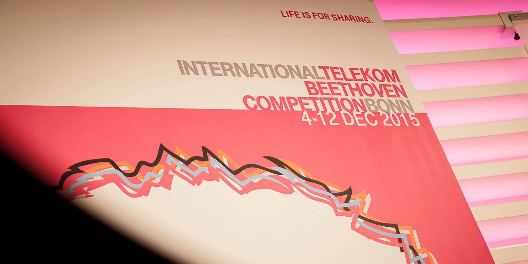 Plakat der Internationalen Telekom Beethoven Competition Bonn vom 4. bis 12. Dezember 2015, mit einem grafischen Design und dem Motto 'Life is for sharing.' im Hintergrund.