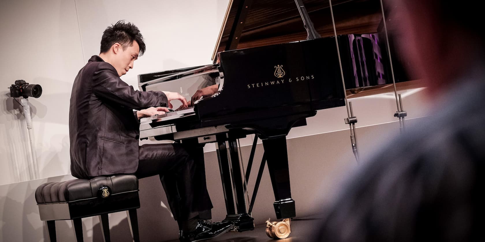 A man playing on a Steinway & Sons grand piano.