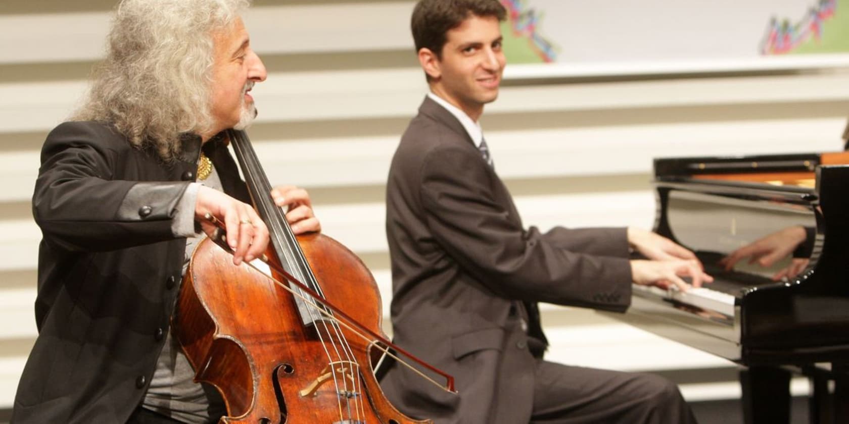 A cellist playing the cello and a pianist playing the piano.