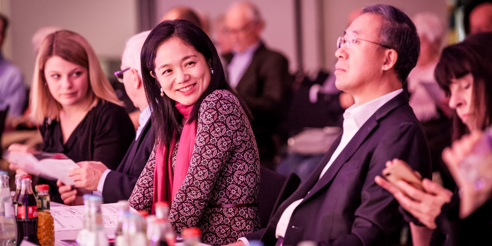 People at a conference sitting at a table and smiling