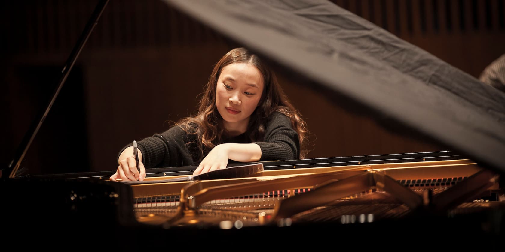 A woman playing the piano attentively.