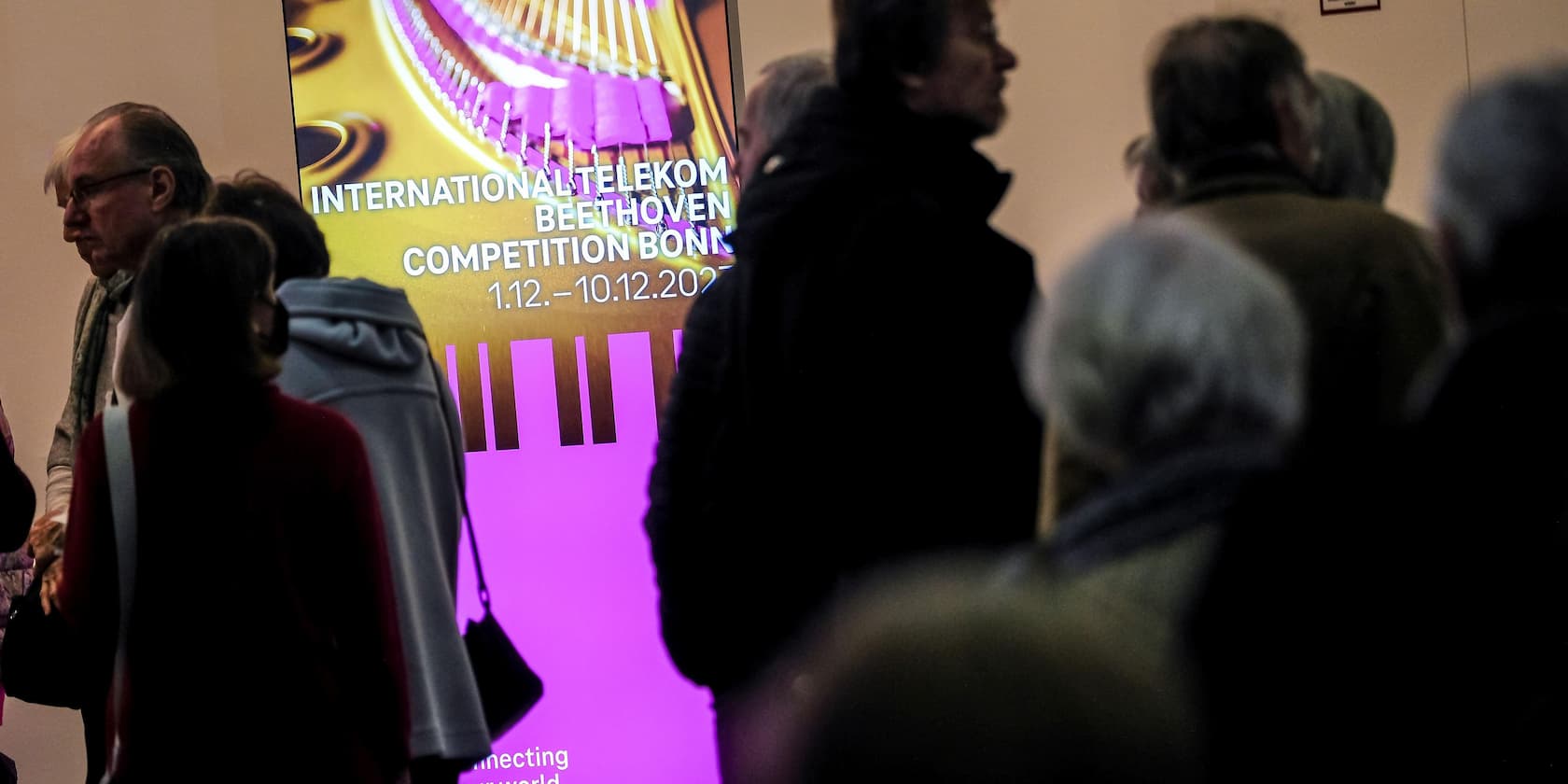 Crowd in front of a screen displaying 'International Telekom Beethoven Competition Bonn 1.12.-10.12.2023'.