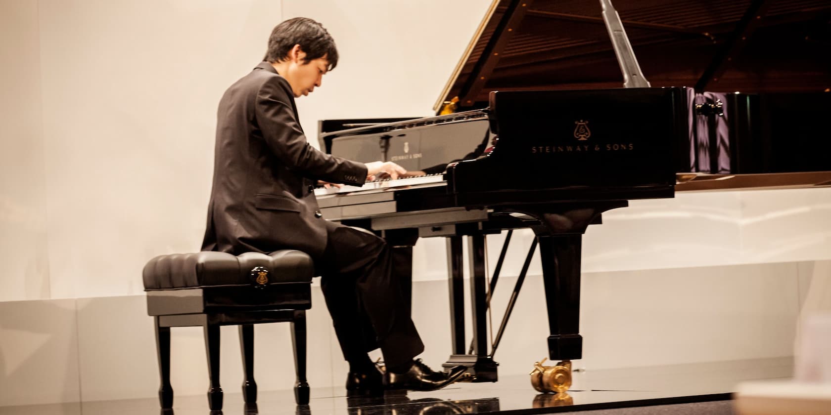 A man playing a Steinway & Sons grand piano.