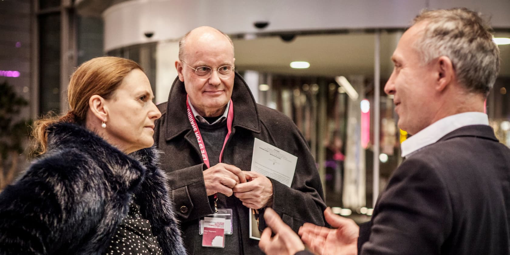 Three people having a conversation at an event.