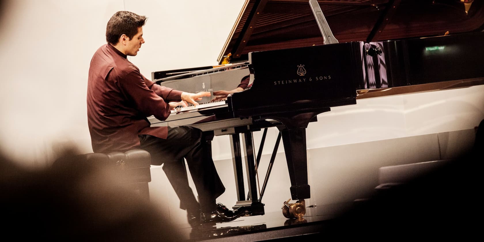 A man playing a piano on a Steinway & Sons grand piano.