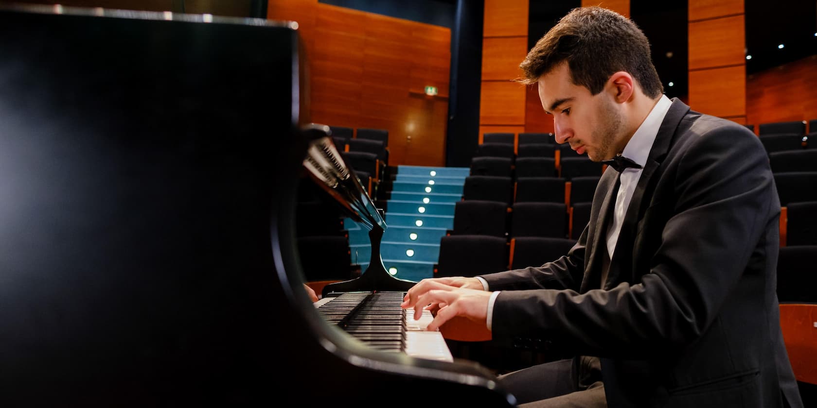 A pianist playing the piano on a stage.