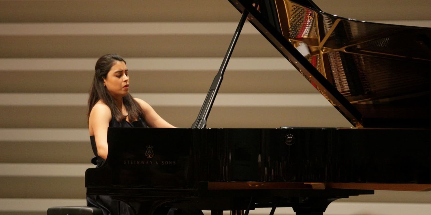 A woman plays the piano in a concert.