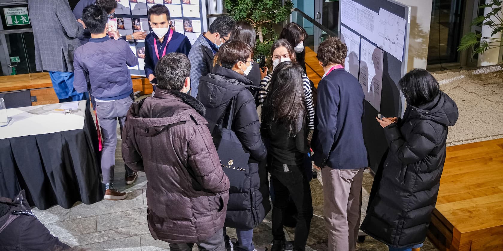 Group of people at a conference looking at an information board.