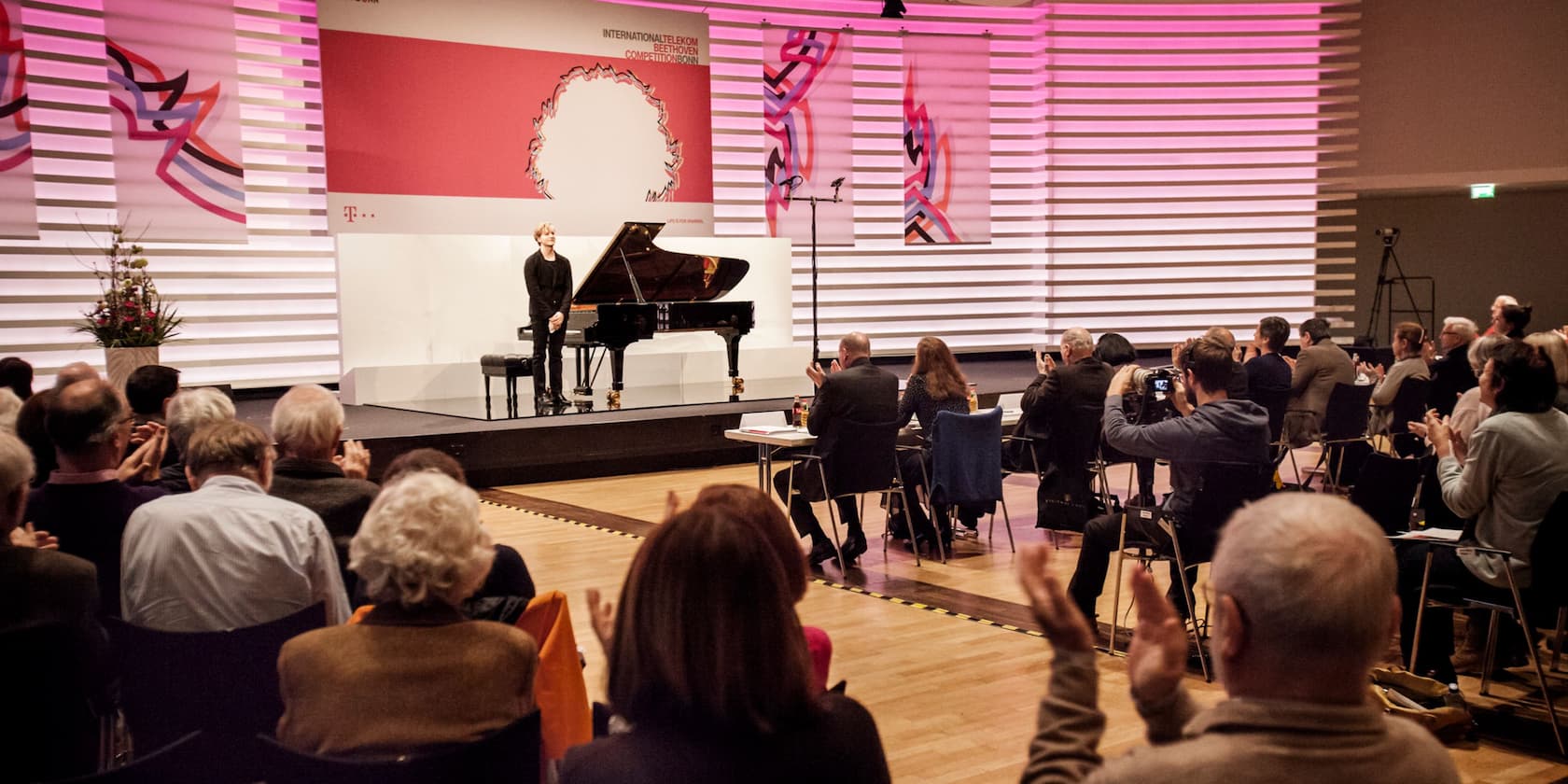 Ein Pianist auf einer Bühne verbeugt sich vor einem Publikum bei der Internationalen Telekom Beethoven Competition in Bonn.