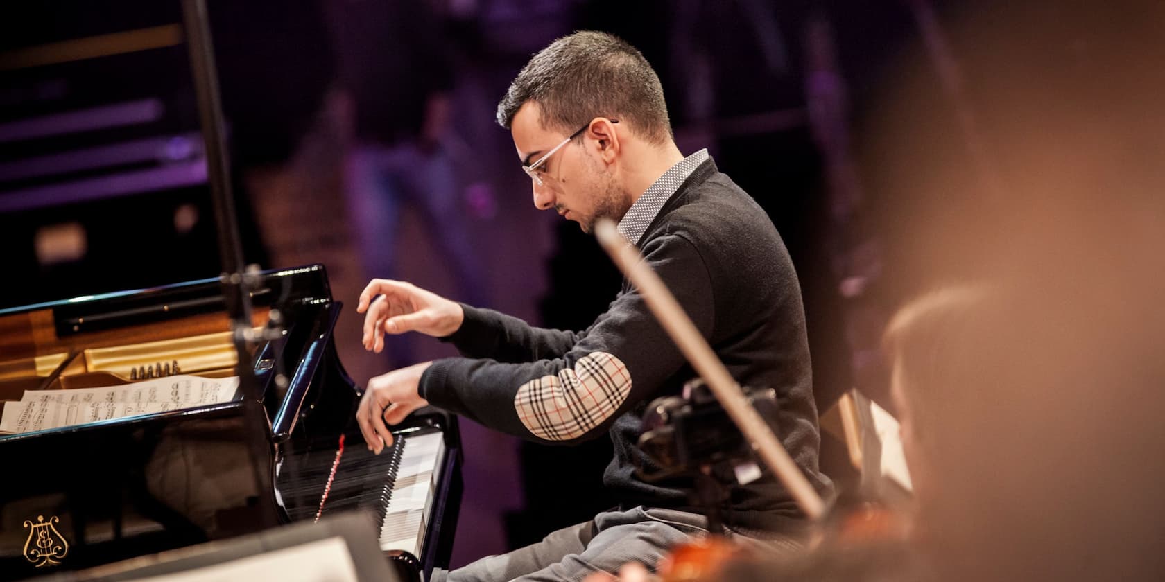 Man playing piano on a stage.