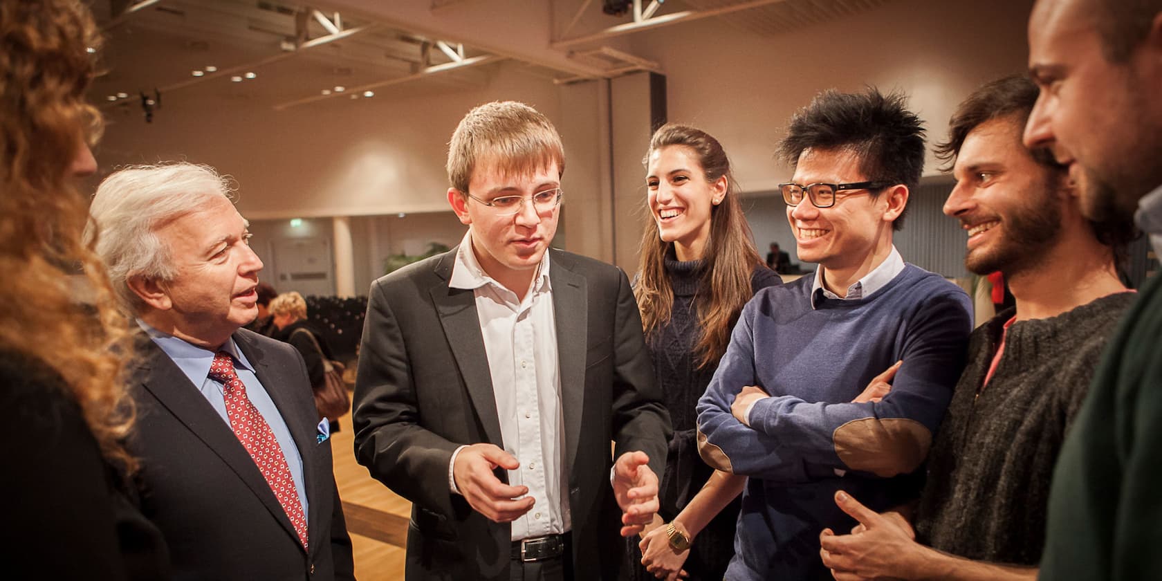 Group of six people having a conversation in a conference room.