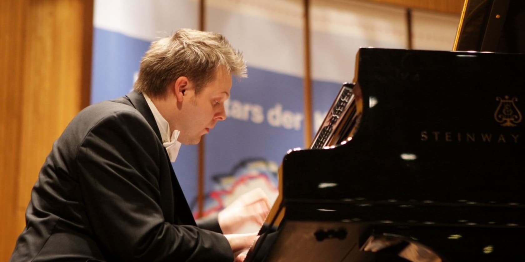 A pianist playing on a Steinway grand piano.