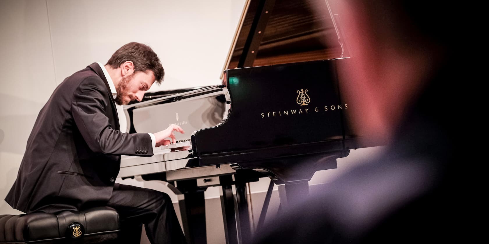 A man is playing a Steinway & Sons piano.