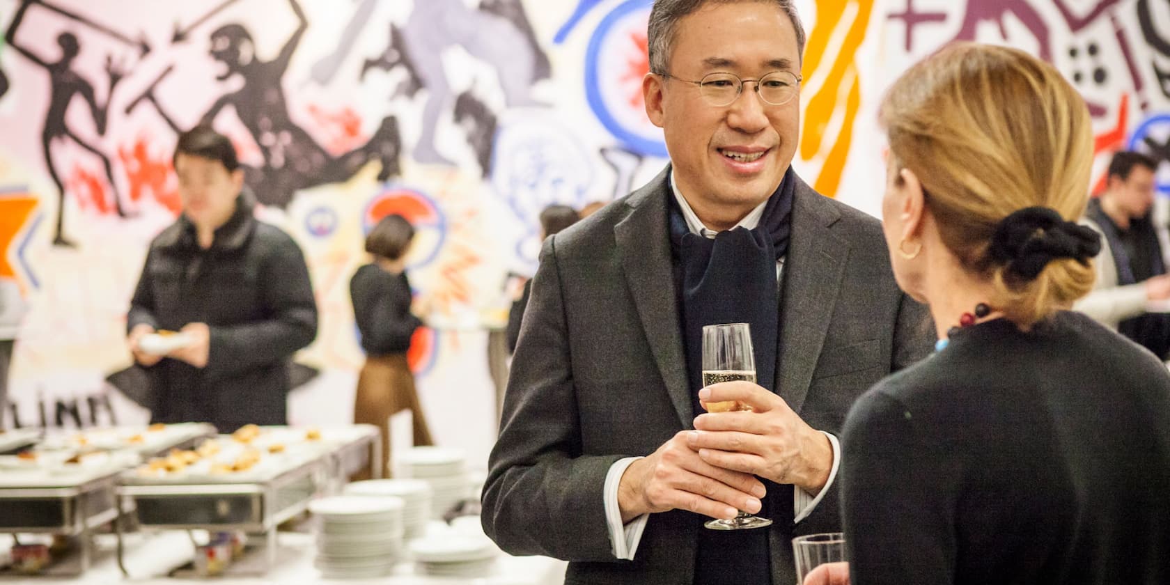 People conversing at an event with food and drinks in the background