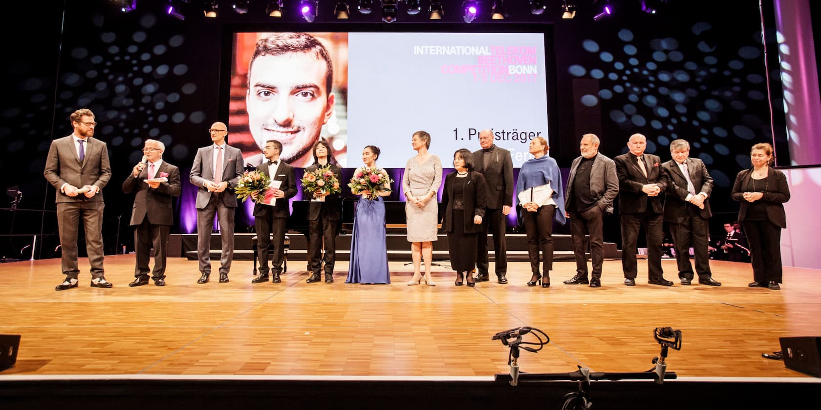 Winners and jury of the International Telekom Beethoven Competition Bonn 2017 standing on a stage.