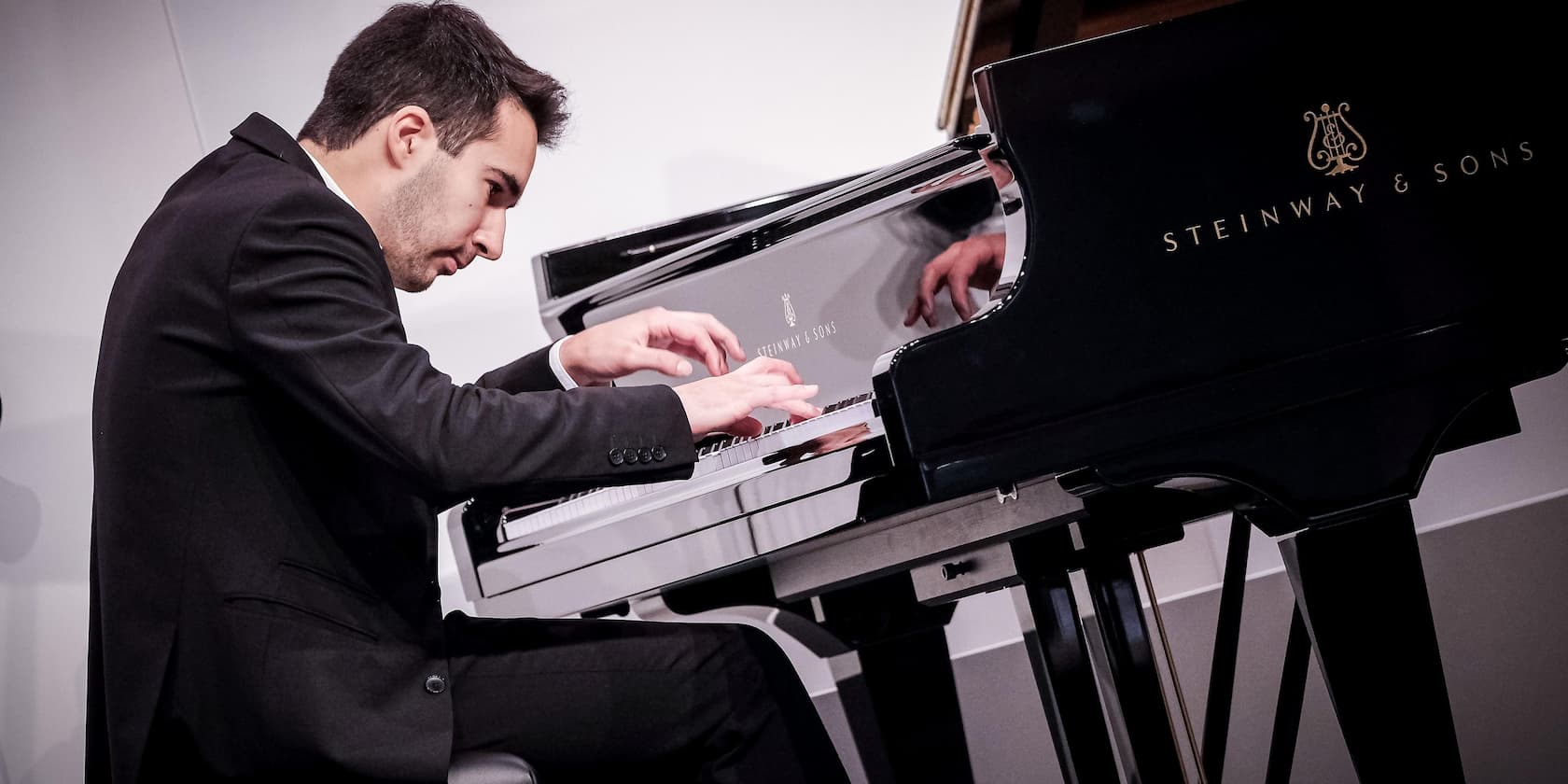 A man playing a Steinway & Sons grand piano