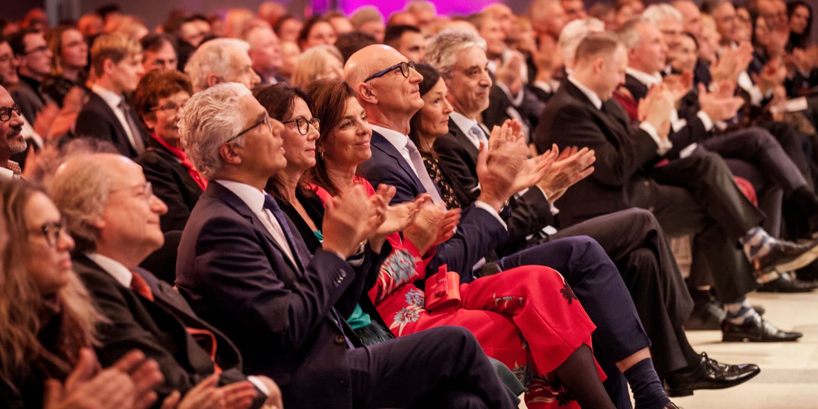 A crowd of people applauding during an event.