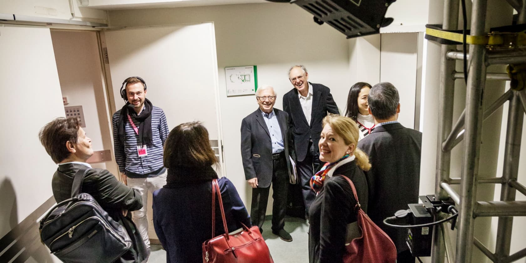 A group of people conversing in a hallway.