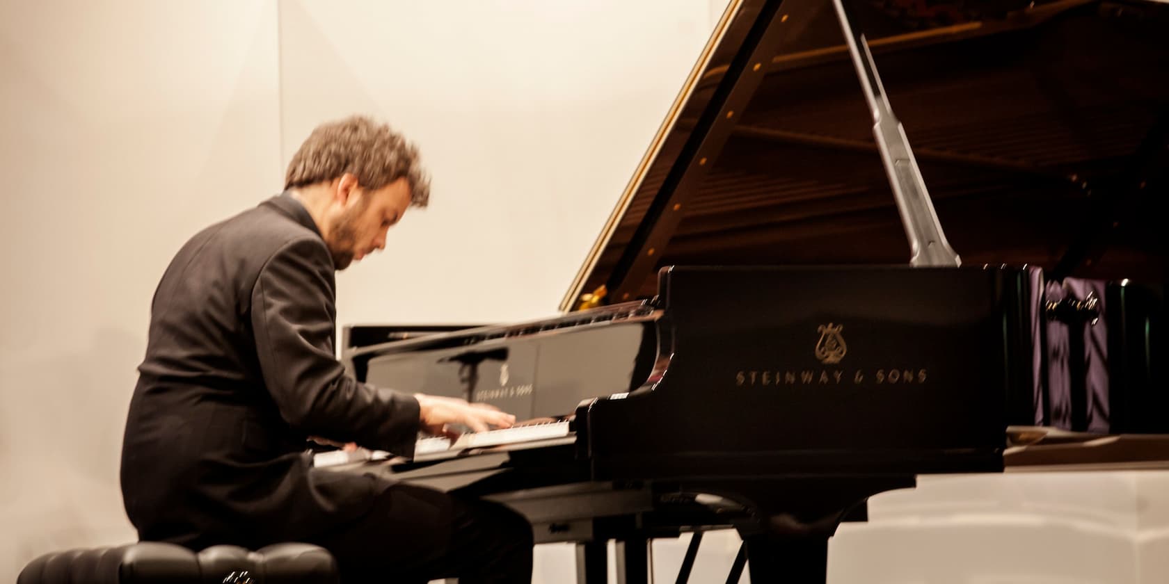 A man playing piano on a Steinway & Sons stage