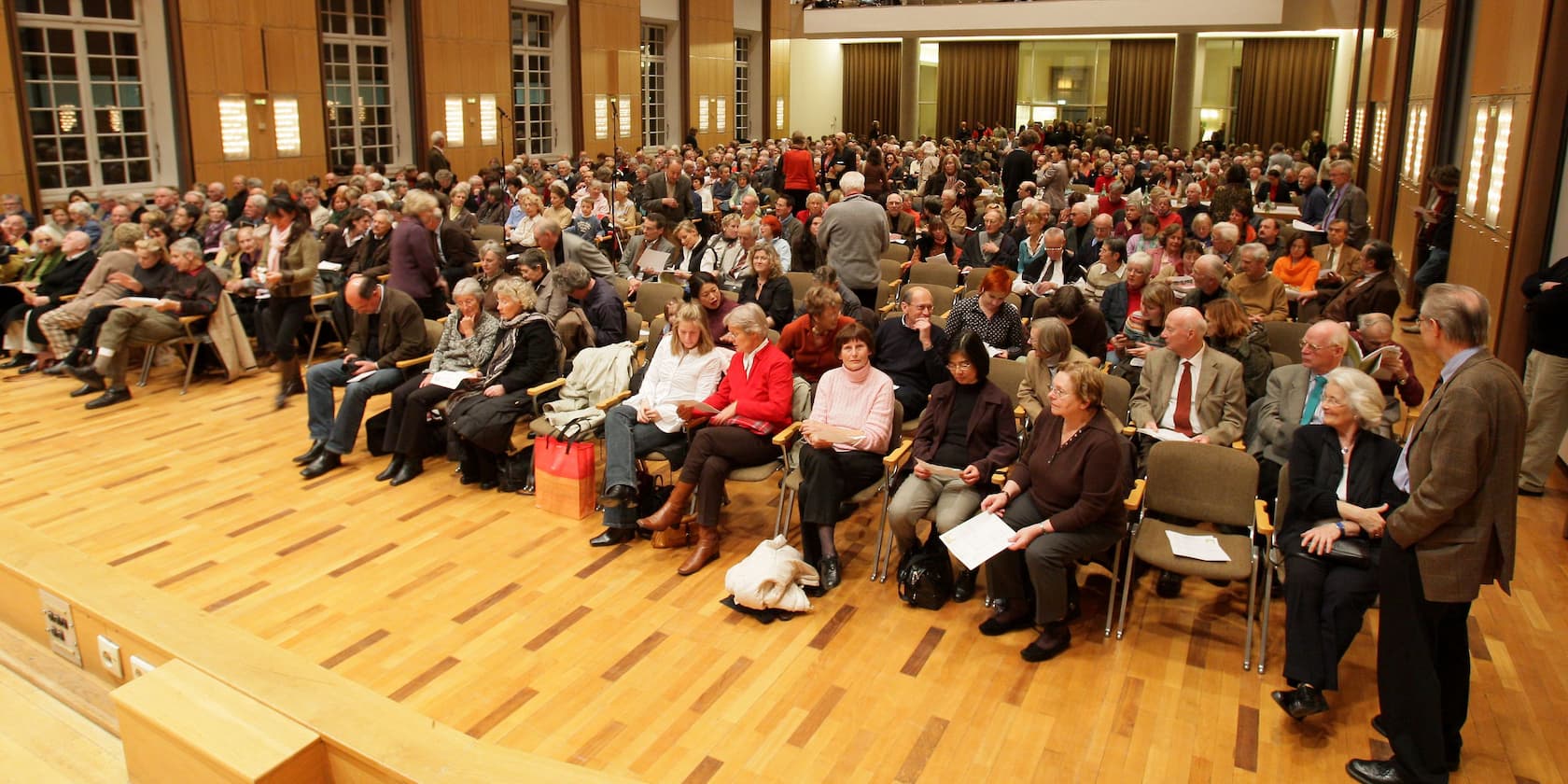 A large group of people seated in an assembly hall.