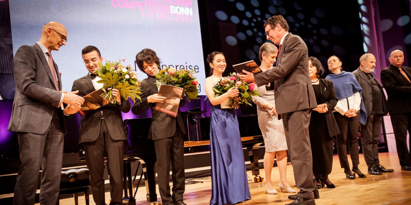 Participants of the Beethoven Competition Bonn 2017 receive awards and bouquets on stage.