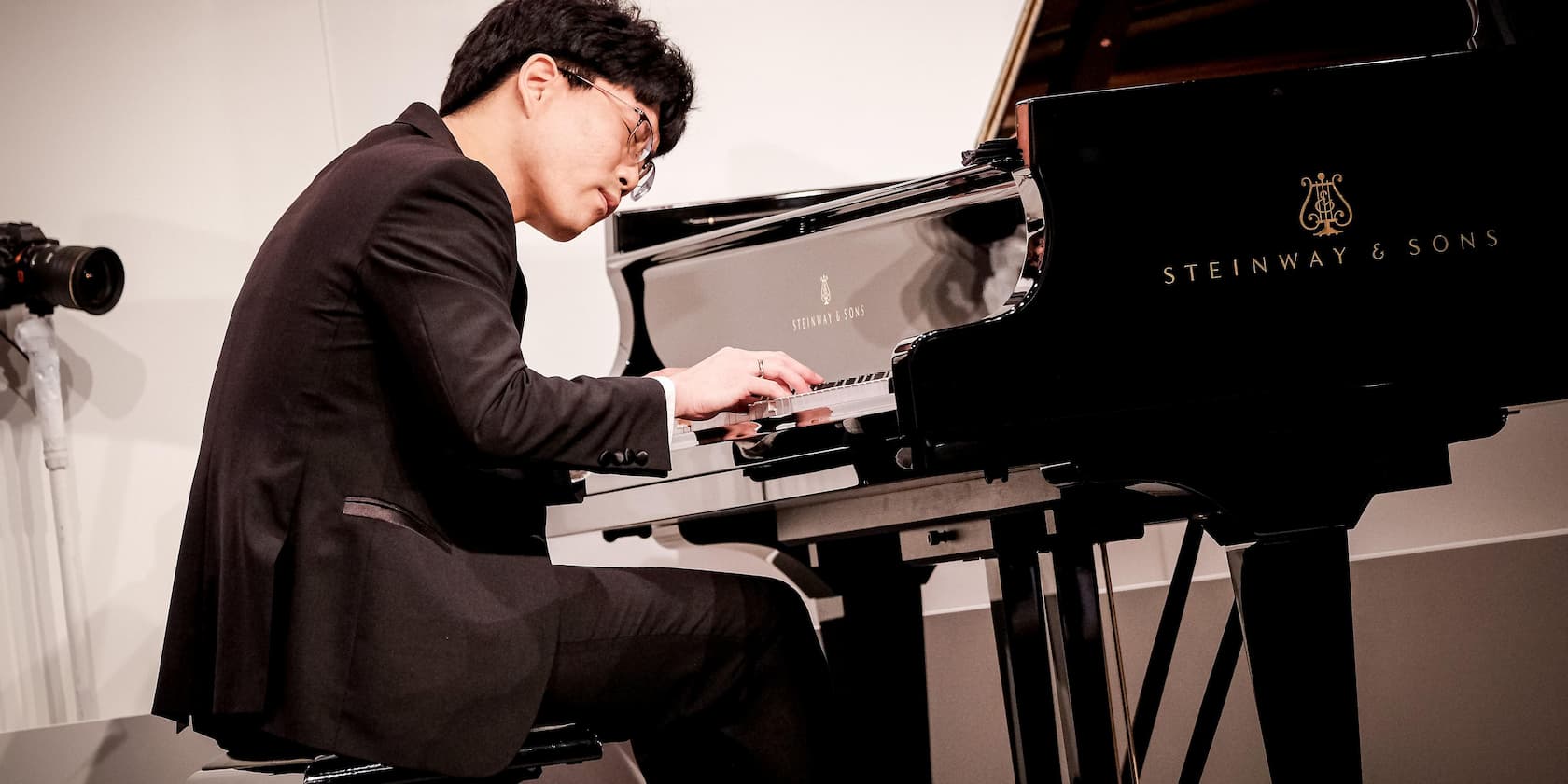 A man playing the piano on a Steinway & Sons grand piano.