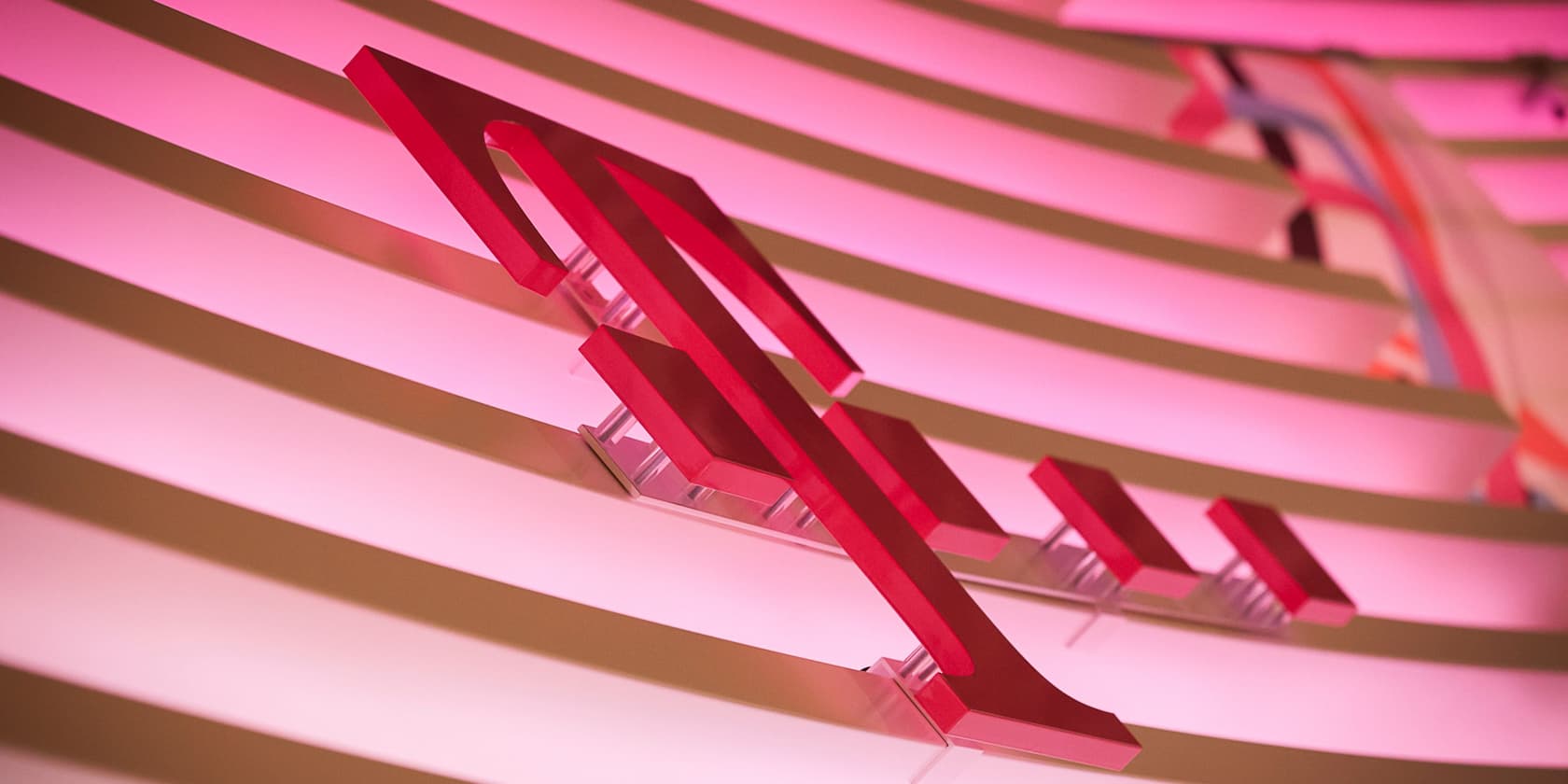 Close-up of the Deutsche Telekom logo on an illuminated pink background