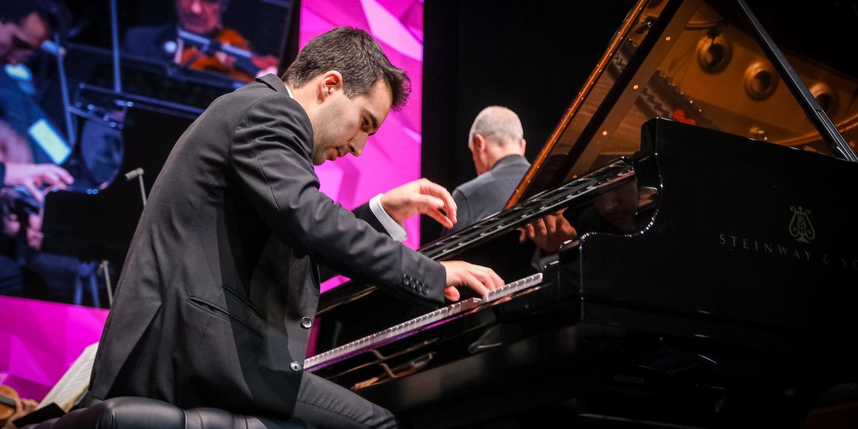 Pianist performs a concert on a Steinway & Sons piano in front of an audience.