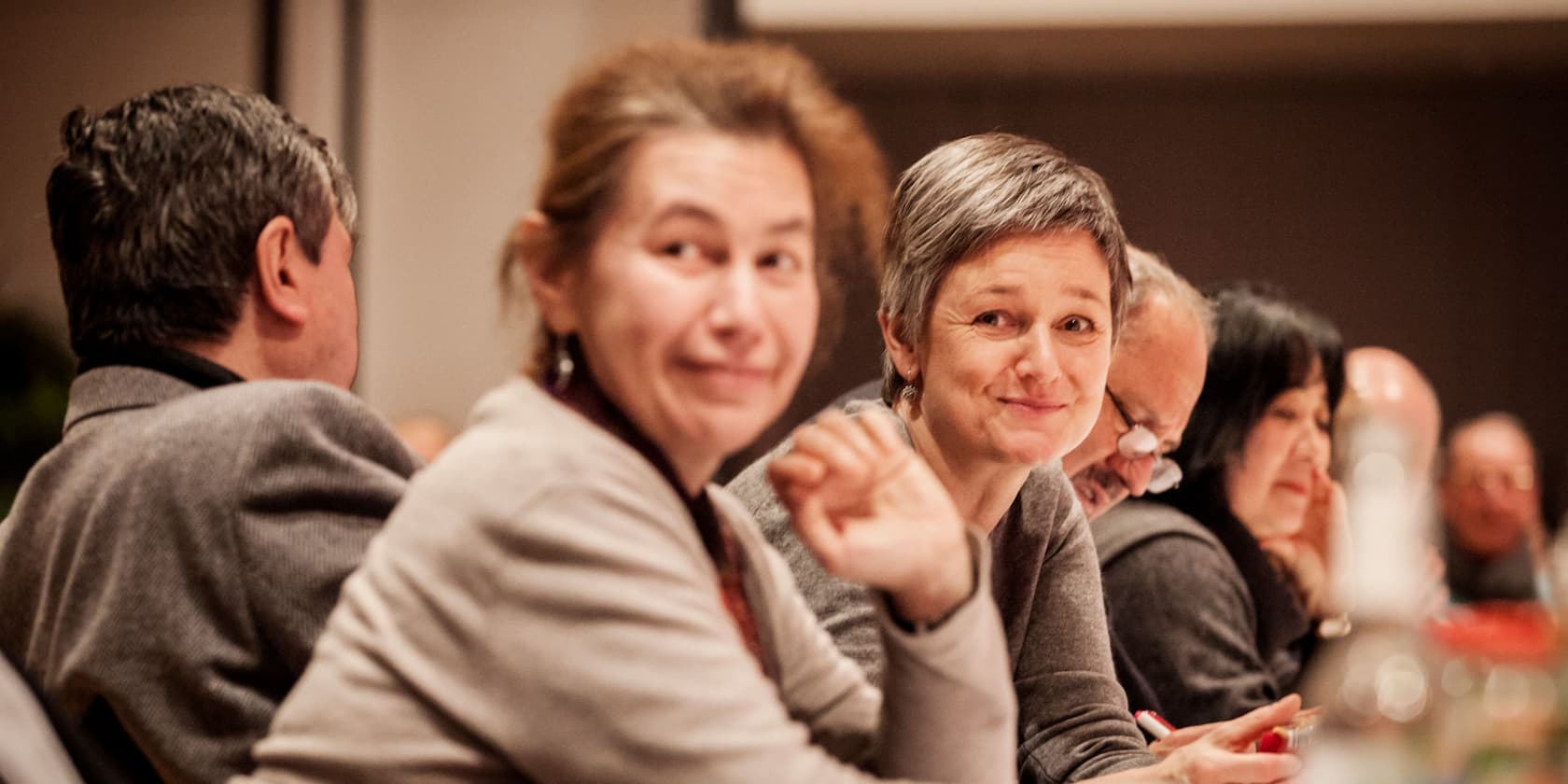 People sitting at a table and smiling.