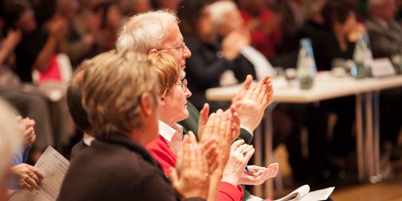 People clapping at an event.