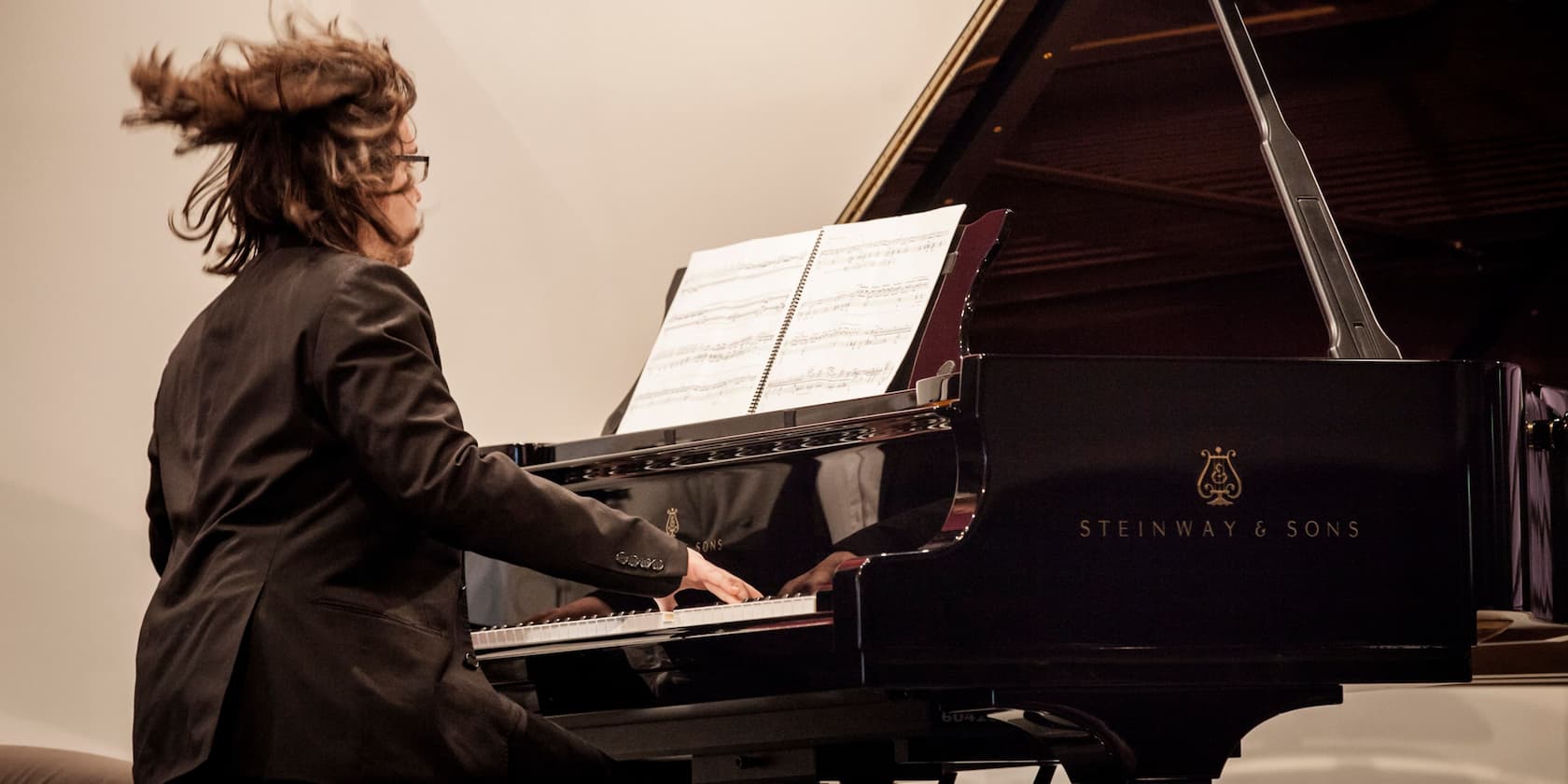 A person playing the piano with sheet music in front of them.