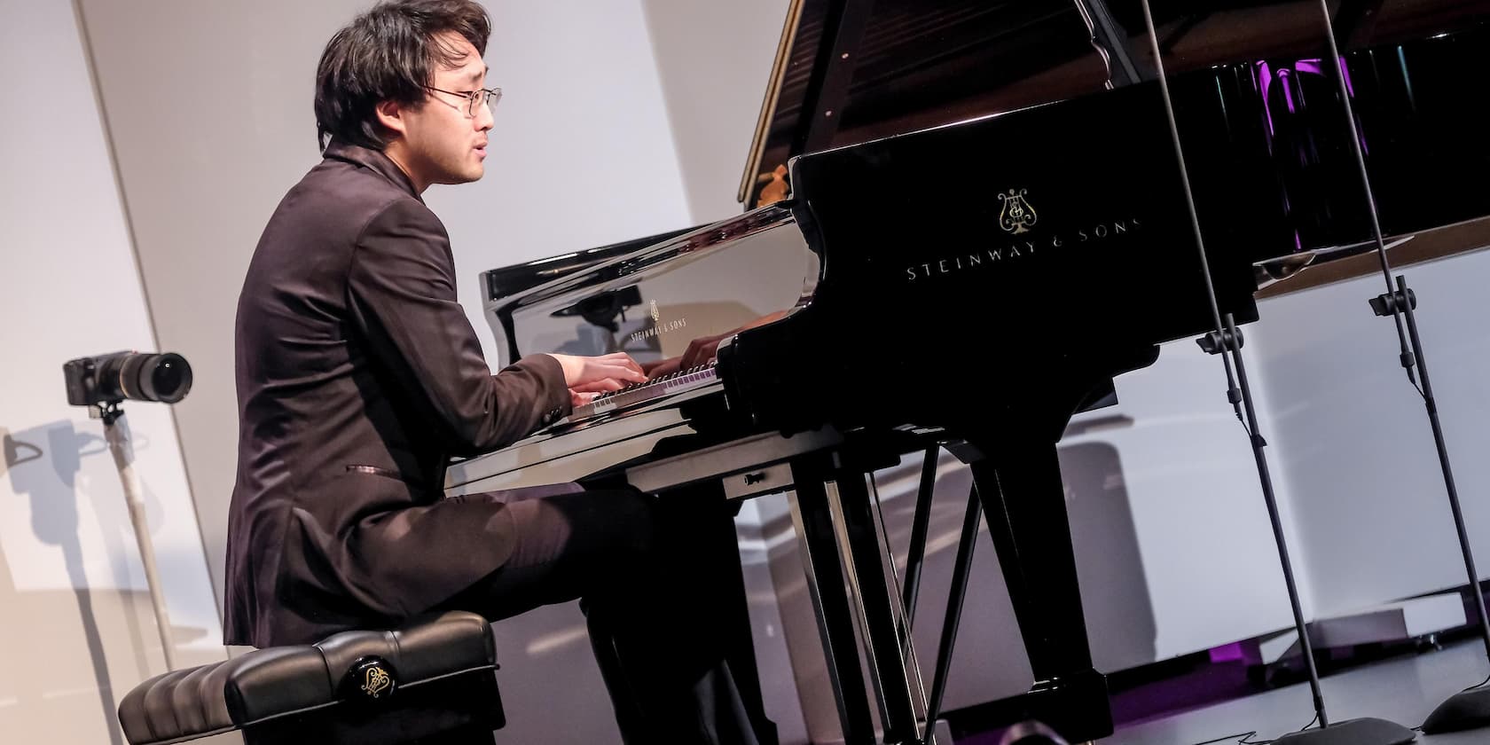 A pianist is playing the piano at a performance.