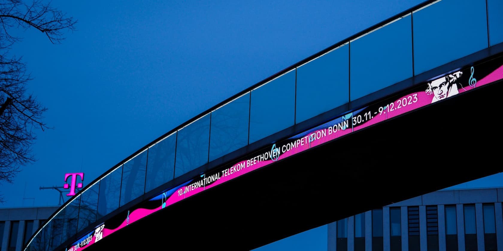 Advertisement for the 10th International Telekom Beethoven Competition in Bonn, 30.11. - 9.12.2023, on a bridge at dusk.