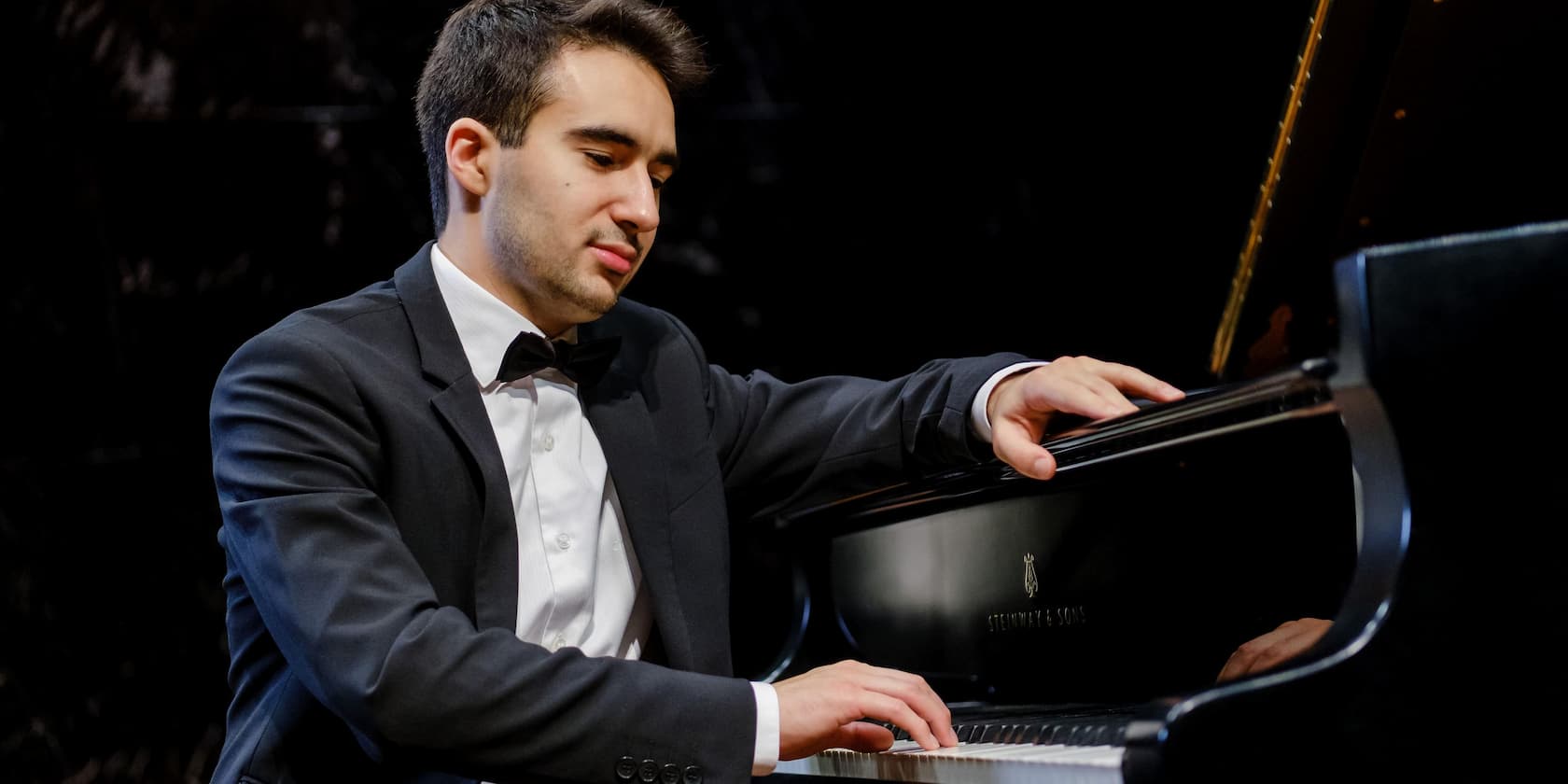 Man in a suit playing the piano.