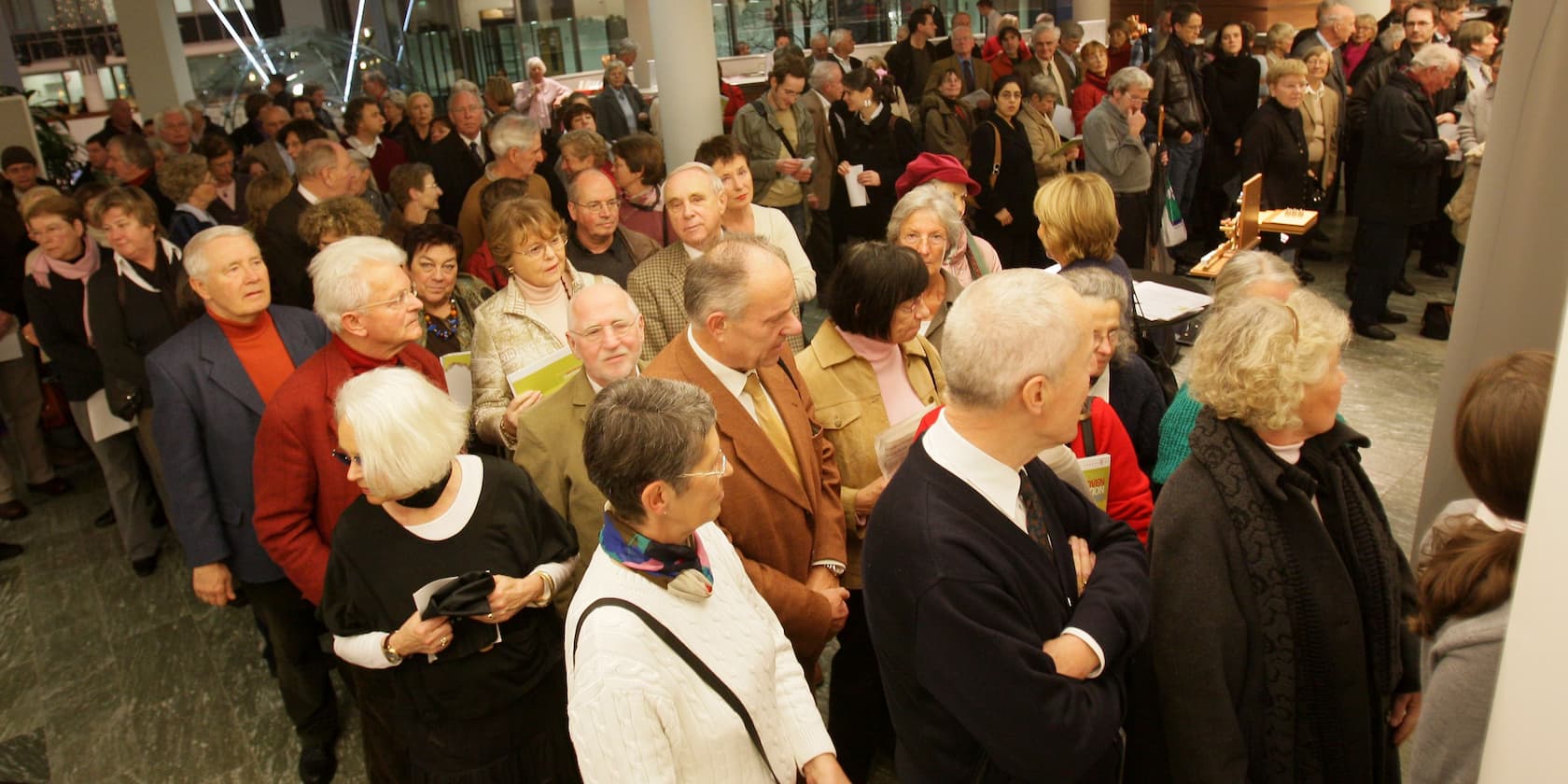 Large group of people standing in line indoors.