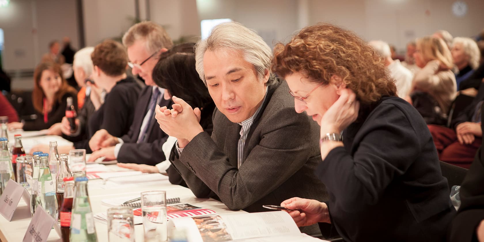 People conversing at a conference table.