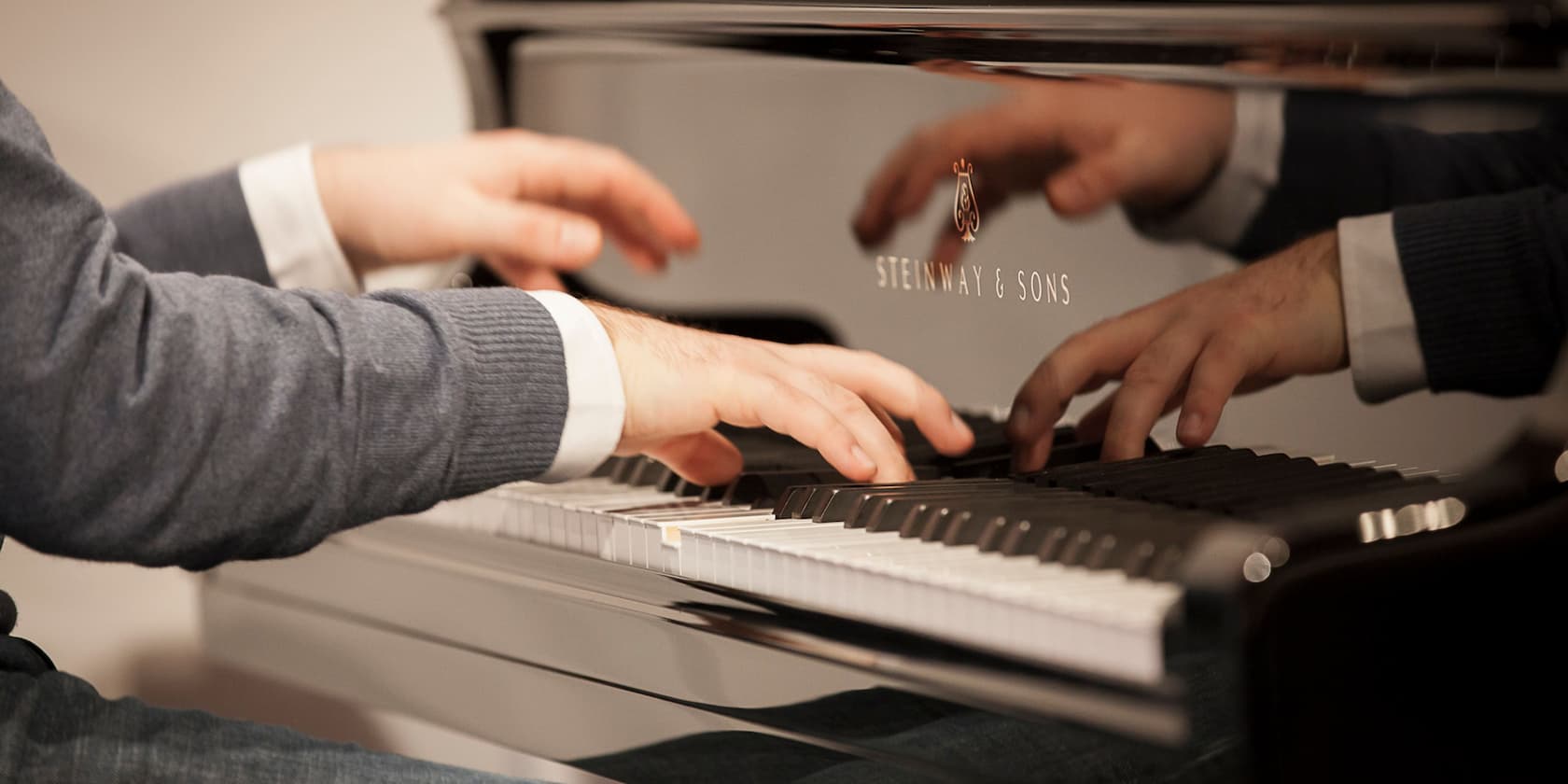 Hands playing on a Steinway & Sons piano.