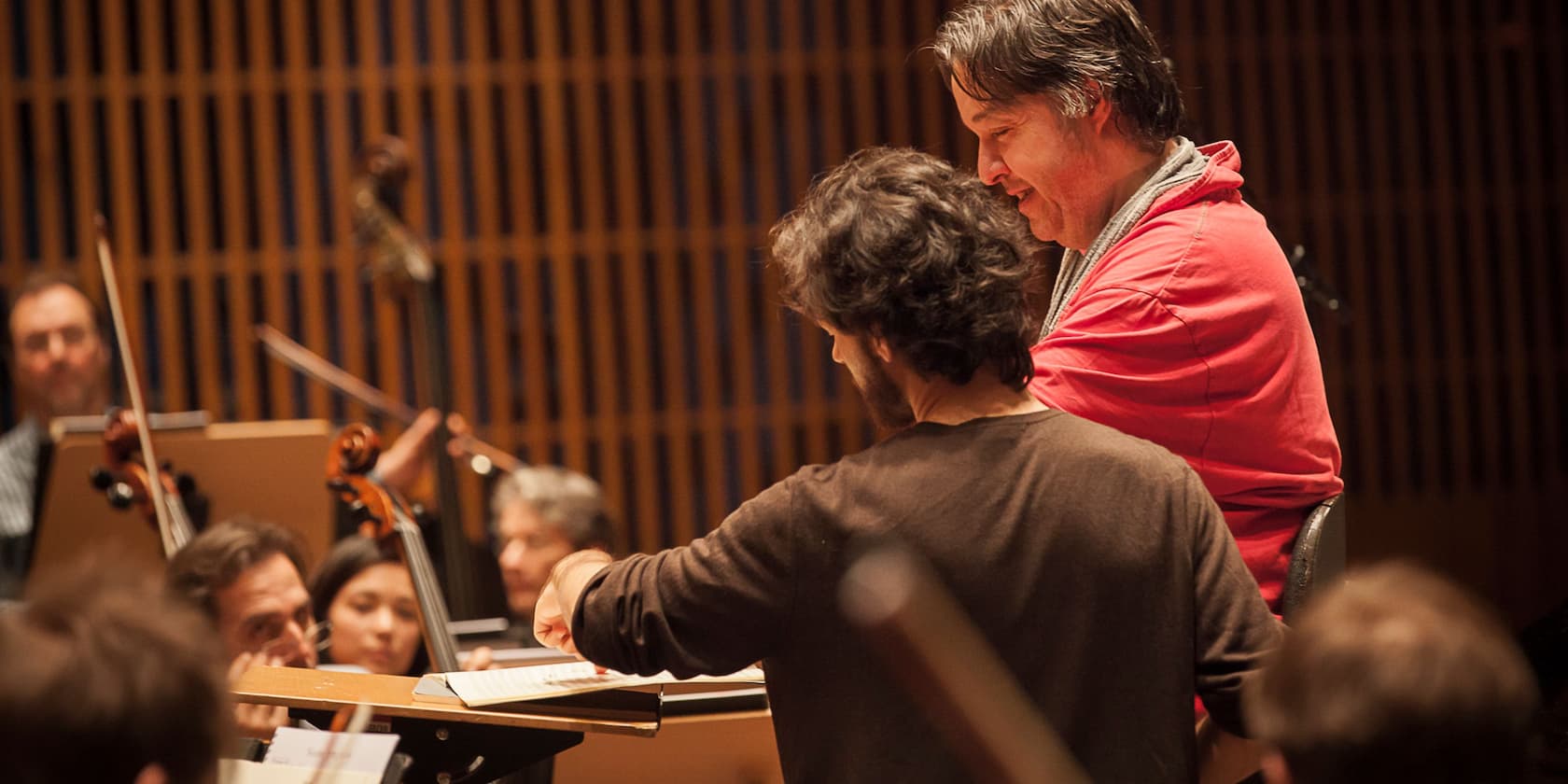 Conductor and musician rehearsing with an orchestra