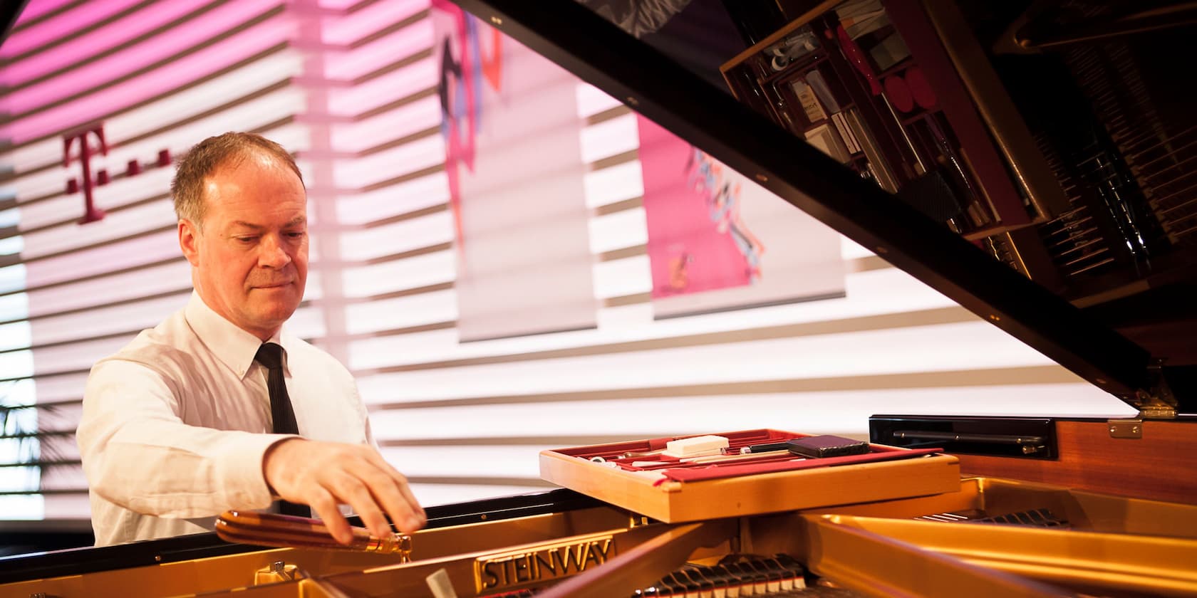 A man playing a Steinway grand piano.