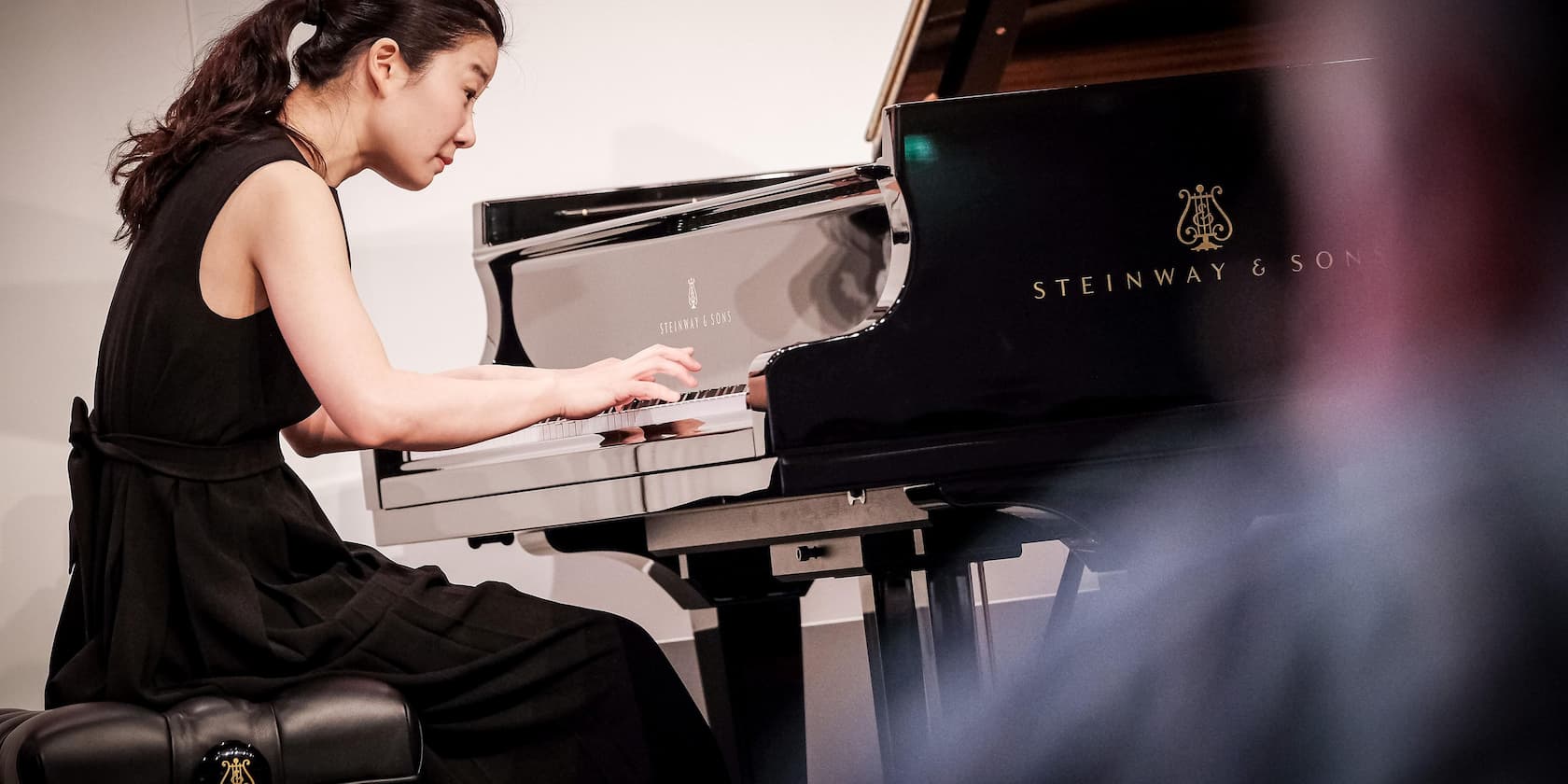 A woman playing a Steinway & Sons piano.