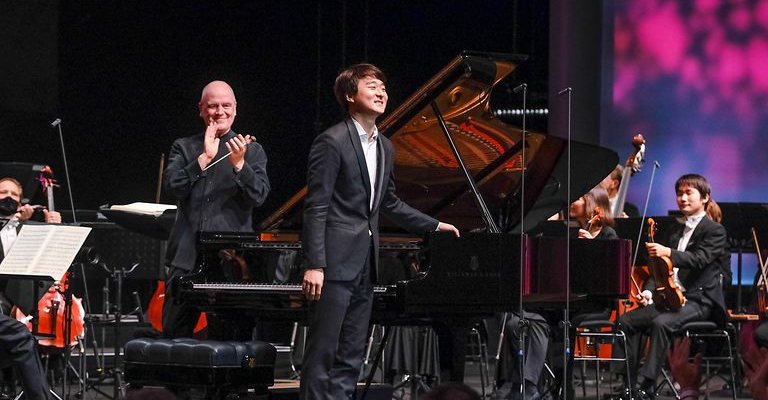 piano player bows to the audience